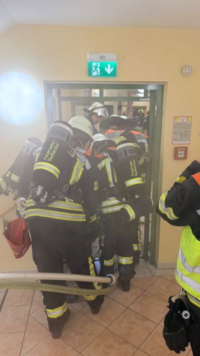 Feuerwehrleute stehen vor der Tür, Übung
